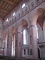 Vue intérieure de l'église. Partie reconstruite après-guerre comprenant arcs brisés, triforium et fenêtres