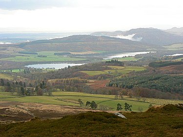 View from Benachally Monument. This is the view towards Loch of Butterstone and Loch of Lowes. Beyond is Newtyle Hill, and on the right of the picture, Birnam Hill. It is just possible to see in front of Loch of Lowes the small stand of trees that appeared above the mist. View from Benachally Monument - geograph.org.uk - 613391.jpg