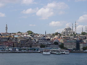Vista do bairro de Eminönü desde o Corno de Ouro. À esquerda ergue-se a Torre de Beyazıt, ao centro encontra-se a Mesquita Yeni, com o Bazar das Especiarias (ou "Egípcio", em turco: Mısır Çarşısı). Em cima, à direita ergue-se a Mesquita Süleymaniye, a maior e mais elevada de Istambul
