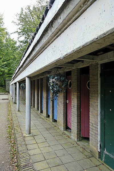 File:Zicht op de voorzijde van de kleedhokjes met een kleine overdekte arcade, behorende bij het voormalige zwembad van het complex - Weert - 20410012 - RCE.jpg