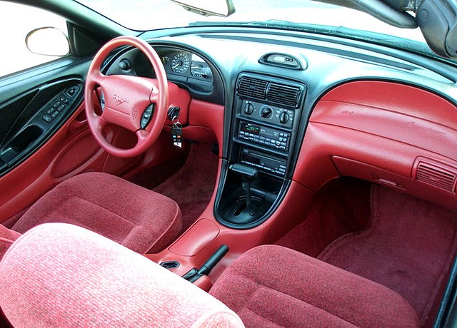 A 1996 Mustang coupe and the red interior of a V6 model. Other interior colors—such as black and beige—were also available.