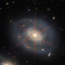 NGC 7469 as imaged by the James Webb Space Telescope. The bright nucleus has caused a diffraction spike that looks like a six-pointed star. A Wreath of Star Formation in NGC 7469 (potm2212a).jpeg