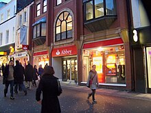 The Abbey National was the first society to demutualise in July 1989. Abbey National bank on Commercial Street, Leeds.jpg