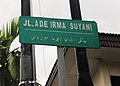 インドネシアのリアウ州・プカンバルにある道路名を記した標識。「アデ・イルマ・スルヤニ通り」（JL. Ade Irma Suyani[注 8]）というインドネシア語の名称がジャウィ文字とラテン文字で併記されている（2013年撮影）。