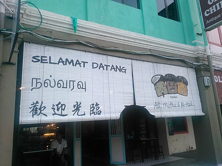A storefront of a Kuala Lumpur kopi tiam that depicts the languages and ethnic groups of Malaysia
