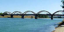 The Clutha passes under the third Balclutha Road Bridge. The first bridge at this site was destroyed during the flood of 1878. Balclutha Bridge over the Clutha River.jpg
