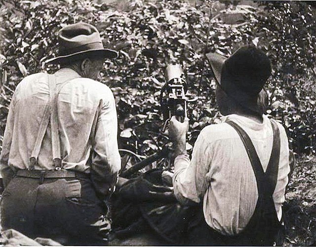 Two union coal miners sitting in a sniper's nest with a machine gun