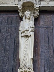 Une statue représentant une femme portant sur le bras gauche une autre femme miniature