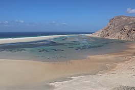 A sandy beach framed by rocky cliffs