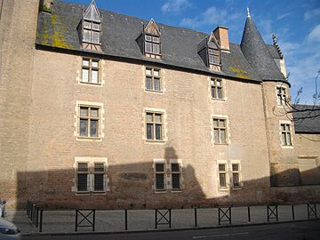 Photo couleur d'un château en brique à toiture d'ardoise à forte pente. Les ouvertures à meneau sont à encadrement de pierre. Celles du rez-de-chaussée sont protégées par des grilles de fer forgé.