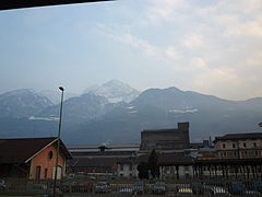 I binari presso la stazione di Aosta, gli stabilimenti dell'acciaieria Cogne e, sullo sfondo, la Becca di Nona e il monte Emilius.