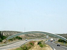 This arch that stretches over a highway indicates the IERS Reference Meridian (0deg) in Spain. Greenwich mean time line.jpg