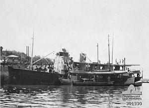 HMAS Southern Cross di Darwin selama bulan juli 1942. Kapal kecil HMAS Griffioen yang ditambatkan bersama dia