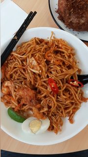 A plate of Malaysian mee mamak with an assortment of toppings