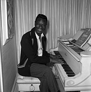 Nat King Cole playing piano at his home, 1964.jpg