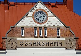 Le fronton du bâtiment de la gare avec texte et horloge.