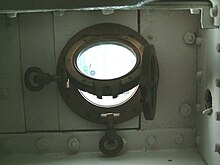 A brass porthole with hinged window and storm cover Porthole of HMS Gannet.jpg