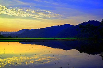 De weerspiegeling van de heuvel in het onbeplante rijstveld. Het Limpung gebied.