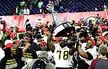 Grambling State Tigers football players raise the trophy after the 2016 championship game SWAC Championship GSU vs. Alcorn 24.jpg