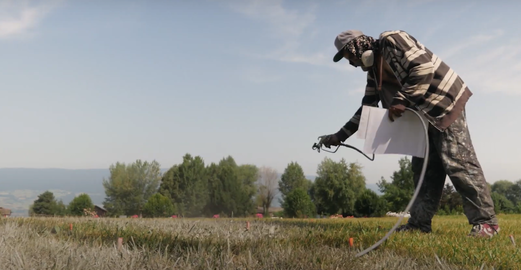 Saype (Guillaume Legros) painting grass for the ArtiChoke festival, 2019