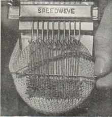 A tiny loom with a heddle made of rotating hooks.
