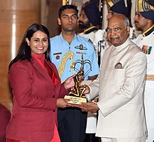 Prezident Shri Ram Nat Kovind Arjuna mukofotini 2018 yil 25 sentyabr kuni Nyu-Dehli shahridagi Rashtrapati Bxavan shahrida porlash marosimida Shreyasi Singx xonimga o'q otish uchun topshirmoqda.