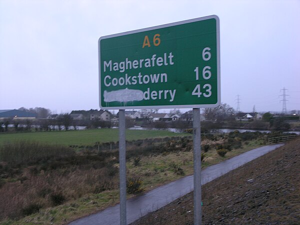 Road sign in Northern Ireland with the reference to London obscured