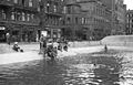 Warsaw 1944, Month before Warsaw Uprising: Children swimming in firefighting water reservoir at Napoleon Square. Behind them Goldstan's townhouse at Plac Napoleona 5 / Moniuszki 1 street and townhouse at Plac Napoleona 7 / Moniuszki 2 street. Further visible lower floors of Prudential building.