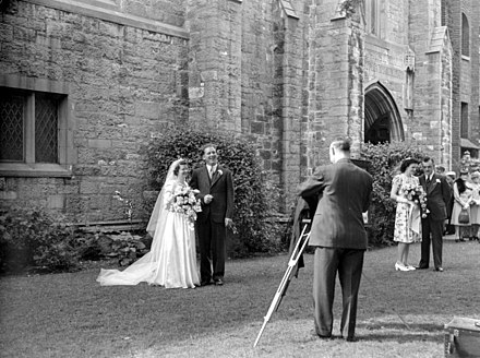 Un photographe spécialisé dans la photo de mariage s'apprête à immortaliser un jeune couple de nouveaux mariés devant une église de Westmount, à Montréal, en 1945.