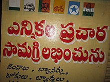 Wall painting at a shop in India. It first shows the painted party symbols of all the major political parties in the region during the nationwide elections in India in 2014. It also has a Telugu inscription showing availability of political flags, banners, caps, badges and other election material.