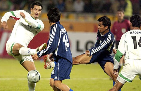 Daei (left) in action against Laos in an international game, 2004