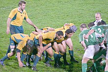 A scrum is preparing to engage. The front row consists of two props on either side of the hooker. The number eight can be seen standing up at the back, while the flankers are bound on the side. Australia - Ireland 15-11-2006-3.jpg