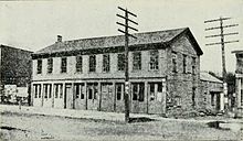 Building in which the Iowa Territorial Legislature first met in Iowa City. Image recorded after the building, which was called Butler's Capitol, had been moved from its original location near Clinton and Washington streets to an alley-side location along Dubuque Street a half-block south of College Street. In this second location, as shown, it became the notorious City Hotel. Building at Iowa City - History of Iowa.jpg