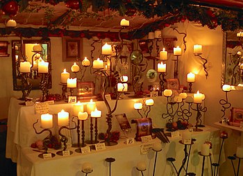 A collection of lit candles on ornate candlesticks
