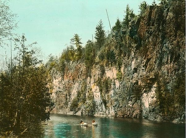 A hand-coloured photograph of canoeists in Algonquin Park in the 1920s