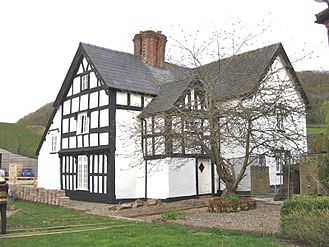 The older timber-framed house on the NW side