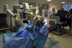 Robot médical utilisant la technique contemporaine (en exposition au Cambridge Science Festival 2015). Le côté réalité de l'opéré : son corps dans l'environnement de la chirurgie de 2015.