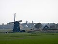 Zicht op de Cornwerdermolen met kerk van Wons