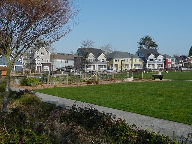 Community garden and open play field with typical house variety in background.