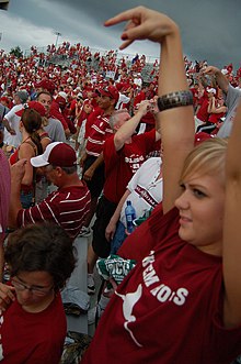 A Sooner fan taunts Texas by making an upside down Hook 'em Horns sign. Horns down at the 2007 Red River Shootout.jpg