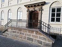 Detail vstupních dveří s pískovcovým portálem a schodištěm