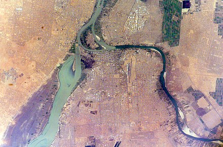Photo satellitaire (par un astronaute) de la zone de confluence des Nil Bleu (à droite) et Blanc. On distingue, de gauche à droite, les villes d'Omdurman, Khartoum et Bahri, et l'île de Tuti au centre du confluent. Et l'on constate que même à leur confluent, et même en début avril au plus fort de la saison sèche (bancs de sable visibles sur le Ni Bleu), les deux affluents sont difficiles à comparer.