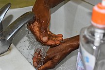 Lavage de mains à l'eau au robinet dans un laboratoire au Bénin. Photographe : Adoscam