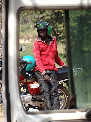 Ein Motorradtaxi-Fahrer wartet auf Kunden, bei Gitarama in Ruanda