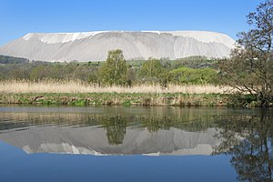 View over the Werra to the smaller area of ​​the two-part conservation area on the other side of the river.  In the background the "Monte Kali", the spoil dump from potash mining.