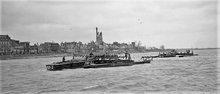 Landing craft operated by the Royal Navy tow pontoon bridge sections into position on the Rhine at Emmerich on 30 March 1945. Naval landing craft on river Rhine.png