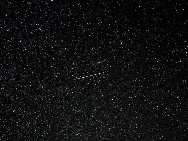 A meteor from the 2023 Perseid meteor shower flying in front of the Andromeda galaxy. Photo by Phiteros