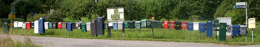 44 stycken postlådor; längst till höger en brevlåda för utgående post. Fotograferade på Helgö i Ekerö kommun.