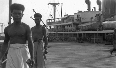 Cargo en attente de déchargement et Papous portant le sarong (1946)