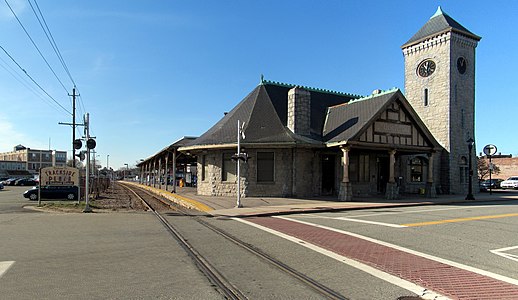 A stone station building with a prominent clock tower